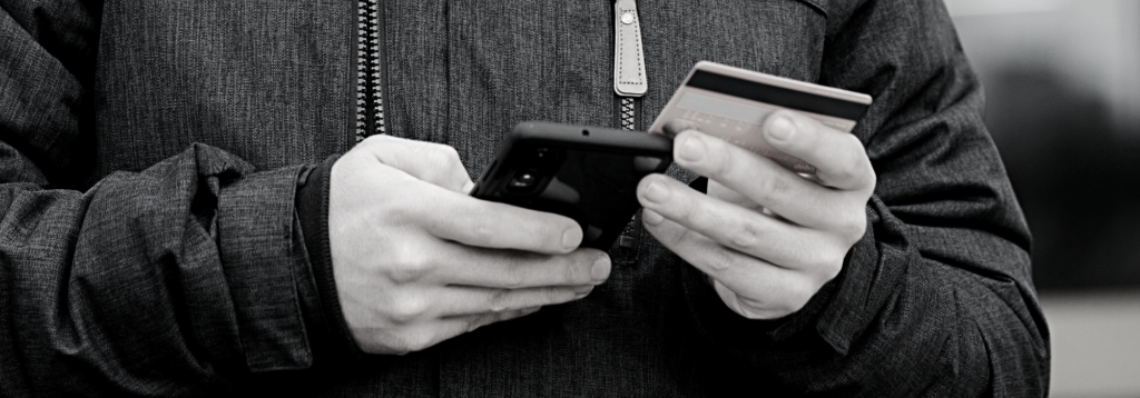 Person accessing digital bank while holding a card and a phone
